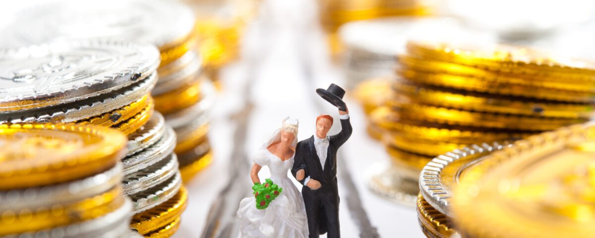 Brautpaar-Figur zwischen Geldmünzen