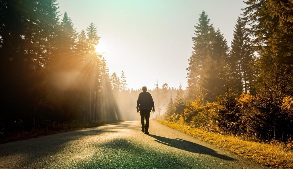 Mann läuft auf der Straße bei Sonnenaufgang