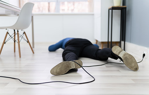 Mann liegt am Boden nach Sturz über ein Kabel