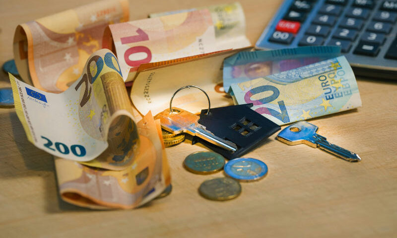 Kaution Geldscheine mit Hausschlüssel auf einem Tisch liegend