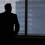 Unternehmer in scharzer Silhouette steht vor einem Fenster - Verletzung insolvenzrechtlicher Kernpflichten
