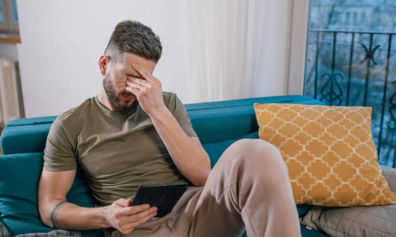 Online AU - Mann auf dem Sofa mit Tablet