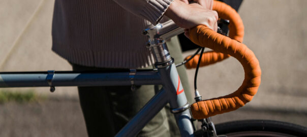 Frau schiebt ihr Fahrrad.