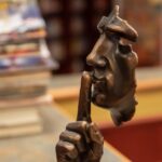 Finger auf den Lippen einer Statue - Schweigen