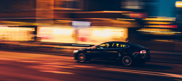 Schnell fahrendes Auto nachts auf der Straße